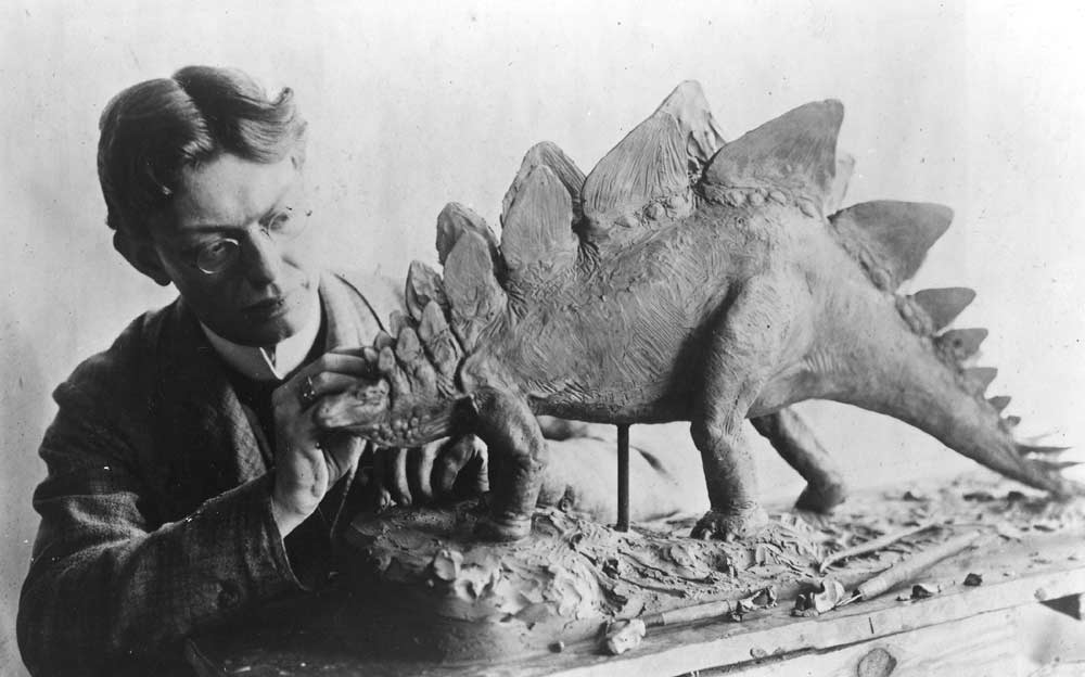 Imagen de Charles R. Knight esculpiendo un estegosaurio
